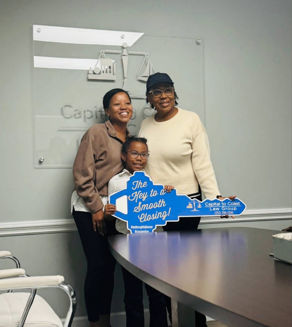 Family with their child holding a closing day key sign
